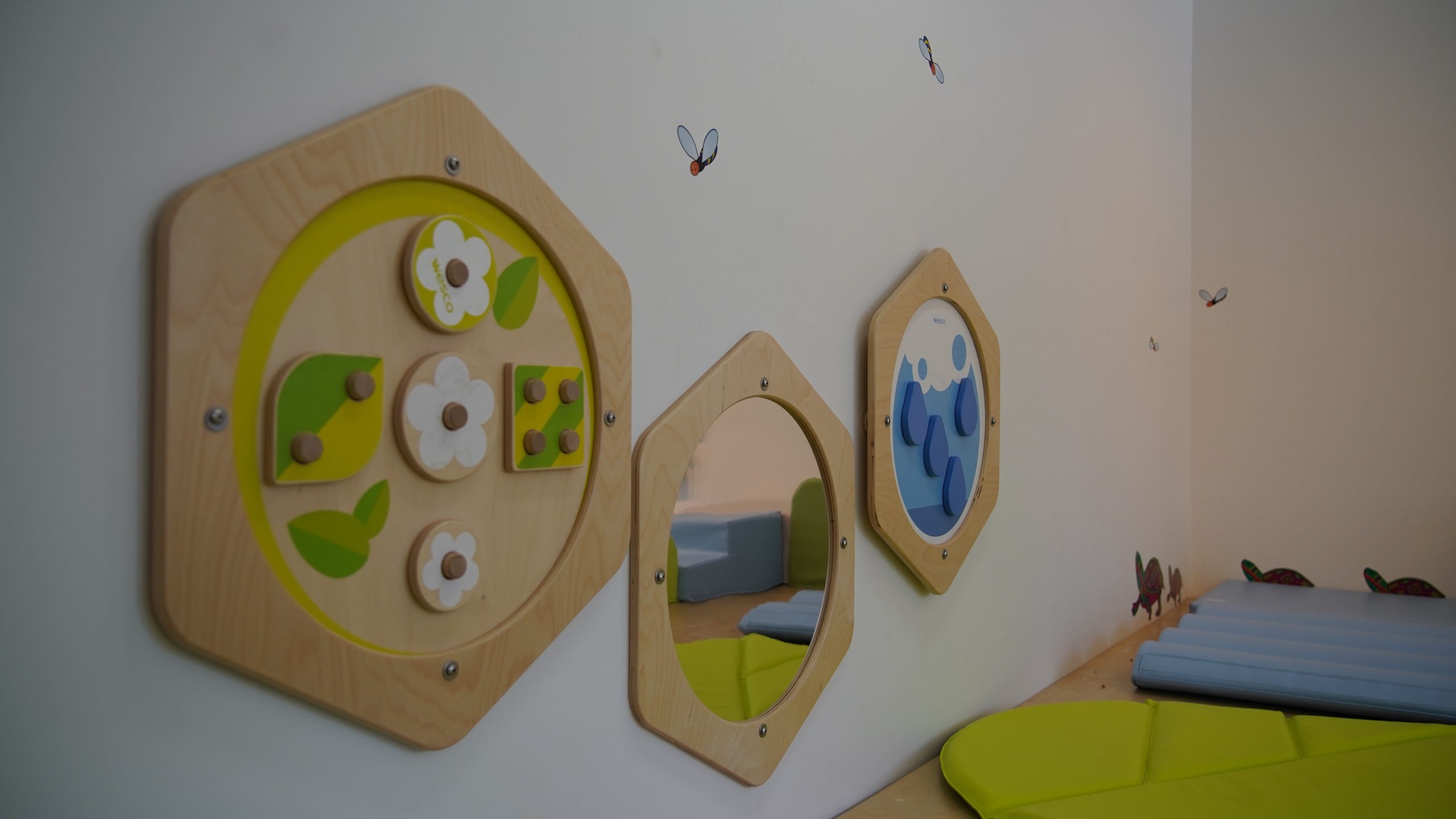 Trois tableaux hexagonaux en bois fixés au mur pour décorer l'espace famille